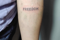 lettering-tattoo-brazo-palabra-freedom-inferno-tattoo-barcelona-1