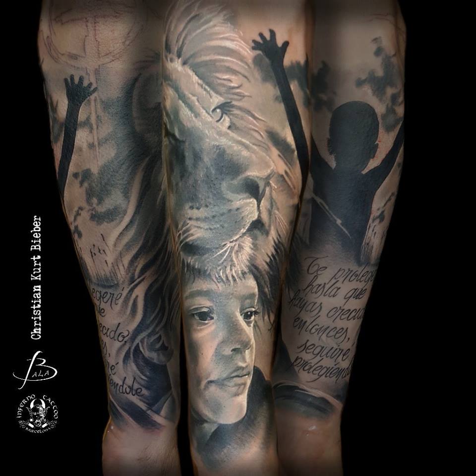 Realismo negro y gris, Christian Kurt Bieber. Tatuaje grande en brazo con niños, león y lettering.