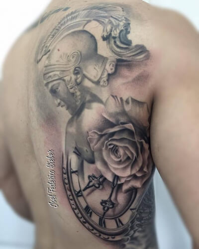 Realismo negro y gris, Joel Federico Bieber. Tatuaje grande en espalda de guerreros, rosa y reloj.