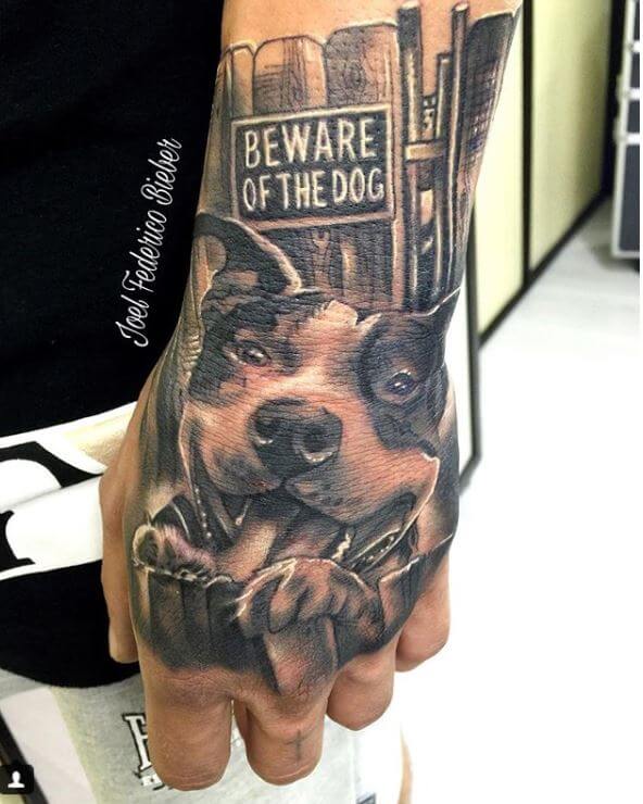 Realismo negro y gris, Joel Federico Bieber. Tatuaje mediano en mano de perro.