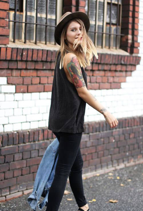 Chica camina con tatuajes en brazo