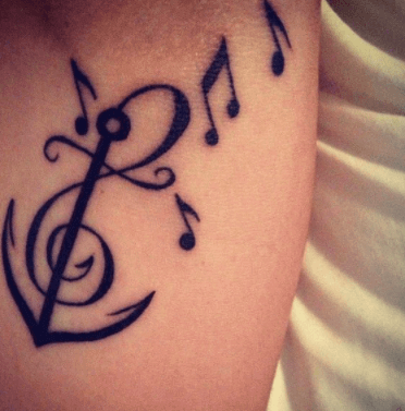 Original combinación de ancla con tatuaje de notas musicales. Pinterest.